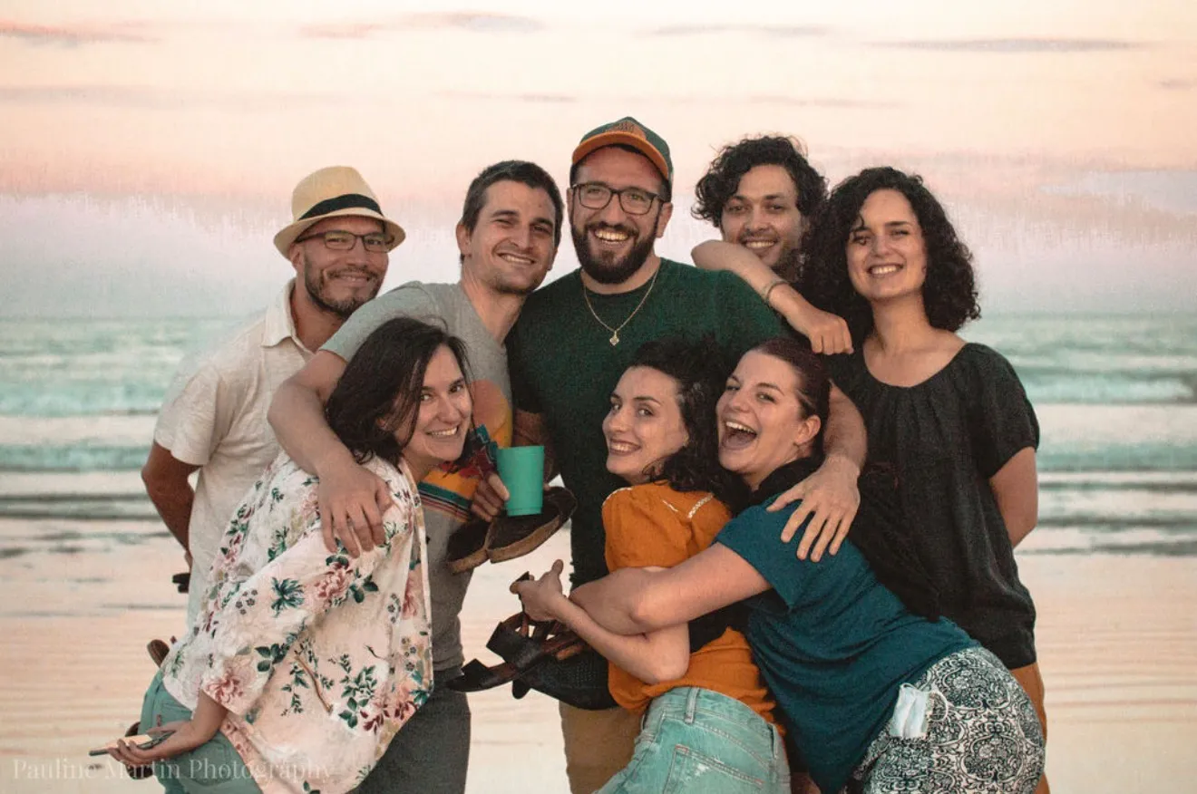 Photo de groupe sur la plage, lumière naturelle.