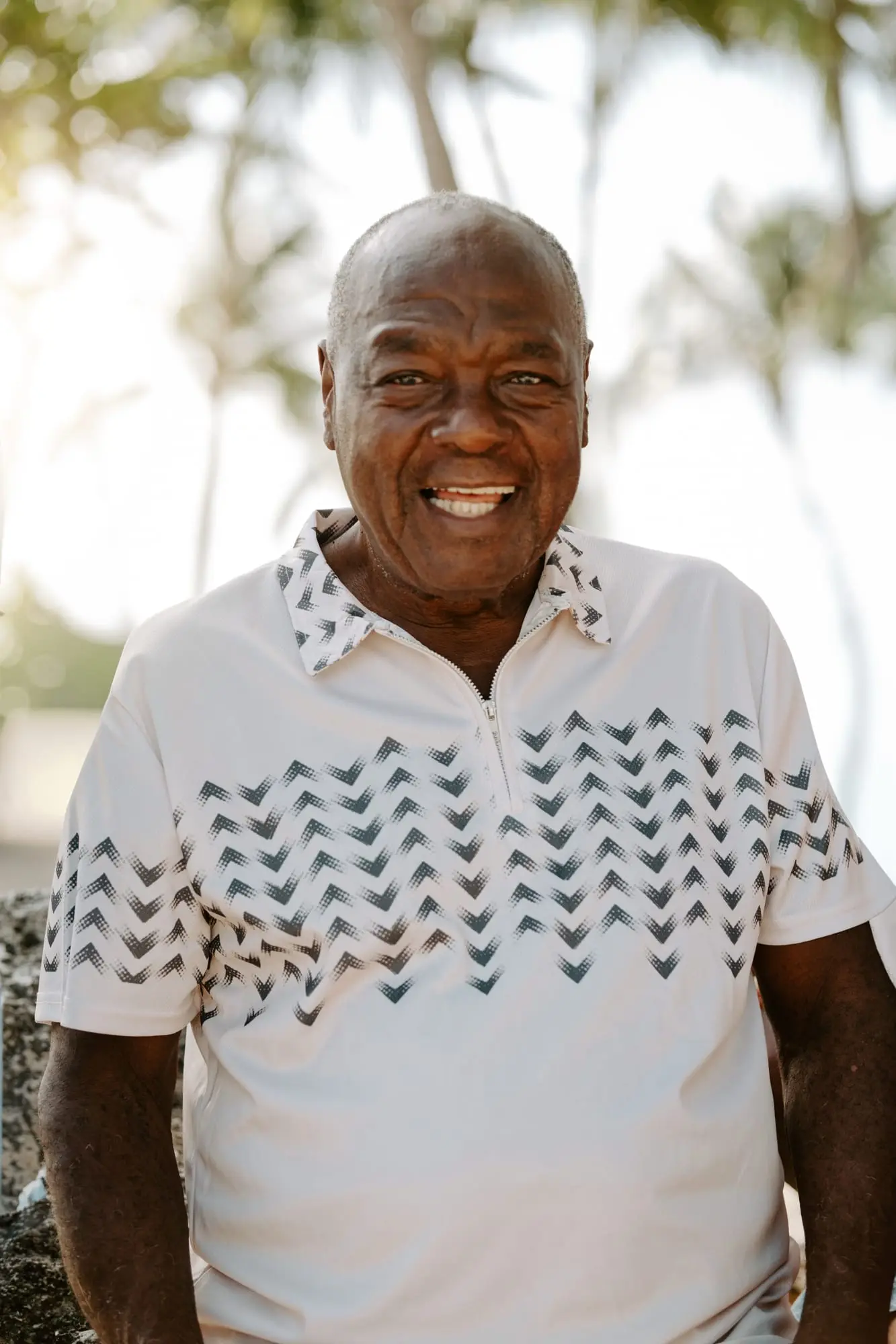 Portrait du grand-père sur la plage de Bois Jolan, à Sainte-Anne : il sourit face à l'objectif, les cocotiers derrière lui.